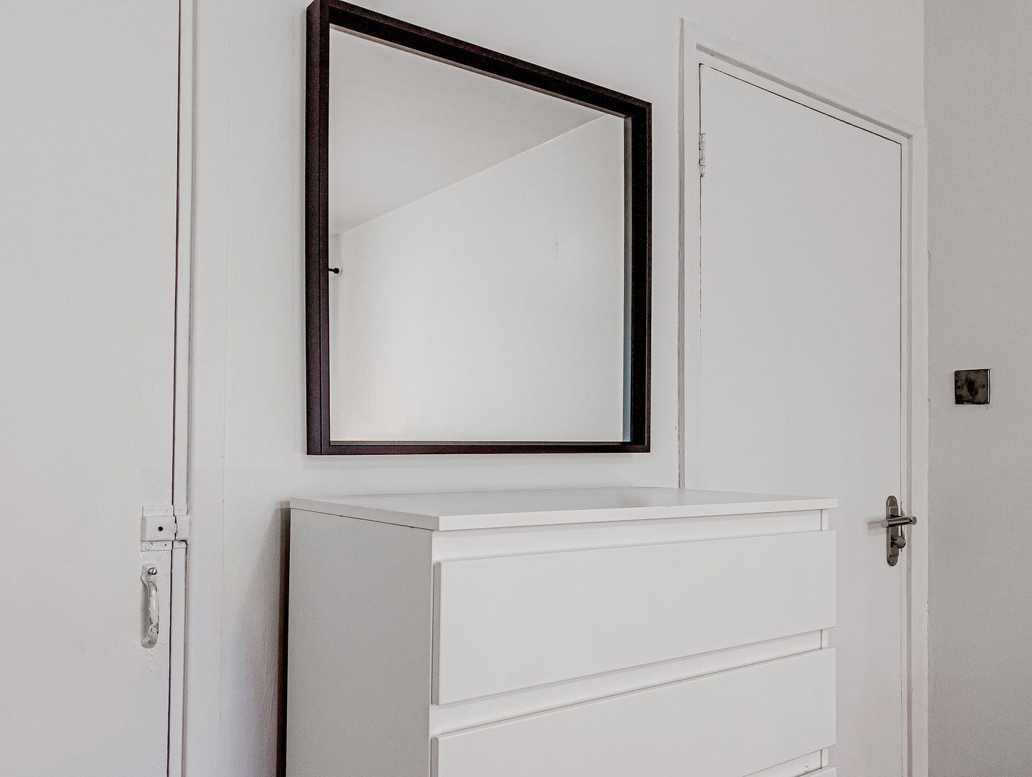 mirror in an airbnb room in central london with a chest of drawers