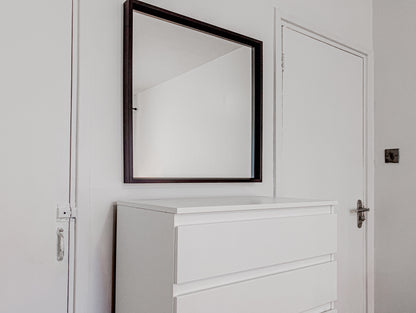 mirror in an airbnb room in central london with a chest of drawers